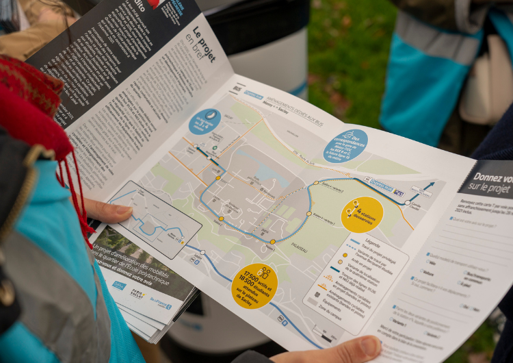 Photo d'une personne regardant le dépliant de la concertation lors des rencontres de terrain